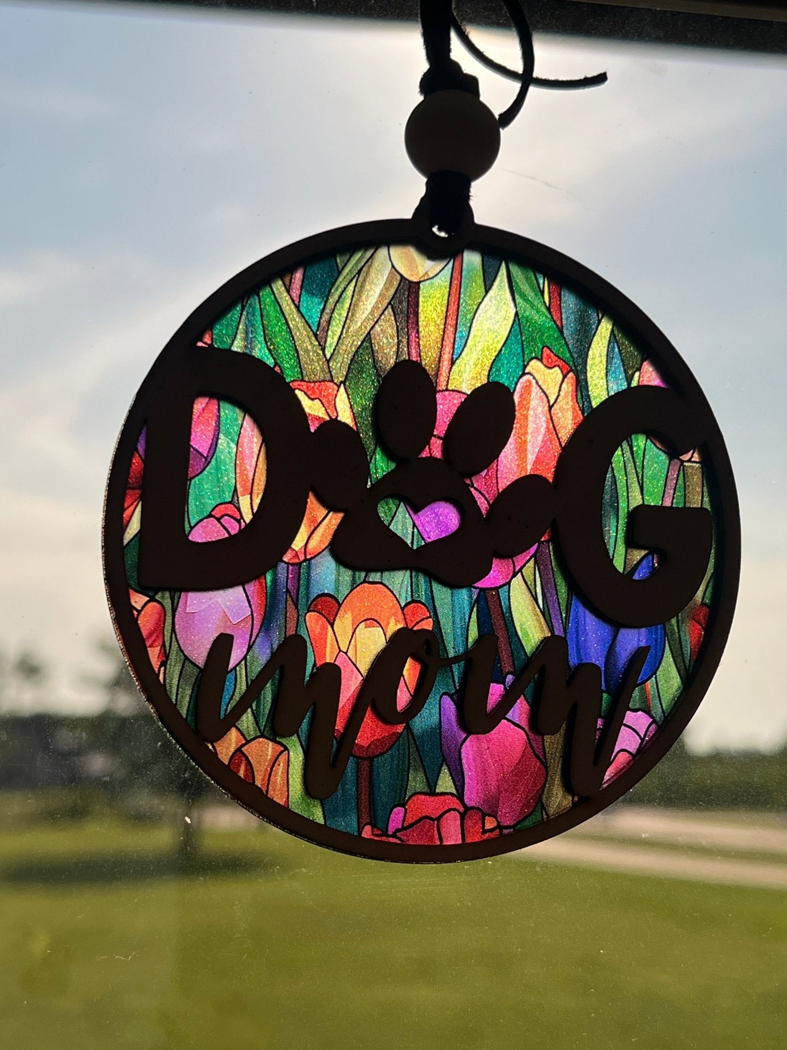 Handmade Dog Mom suncatcher with natural wood and multicolor acrylic offering a rustic stained glass effect in sunlight.