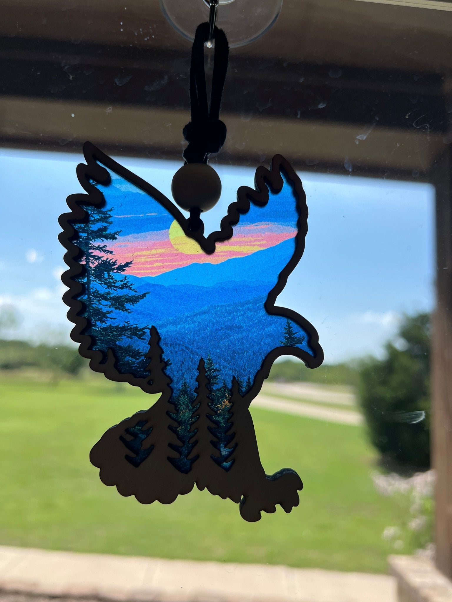 Eagle in Flight suncatcher with wood and multicolor acrylic design in sunlight.