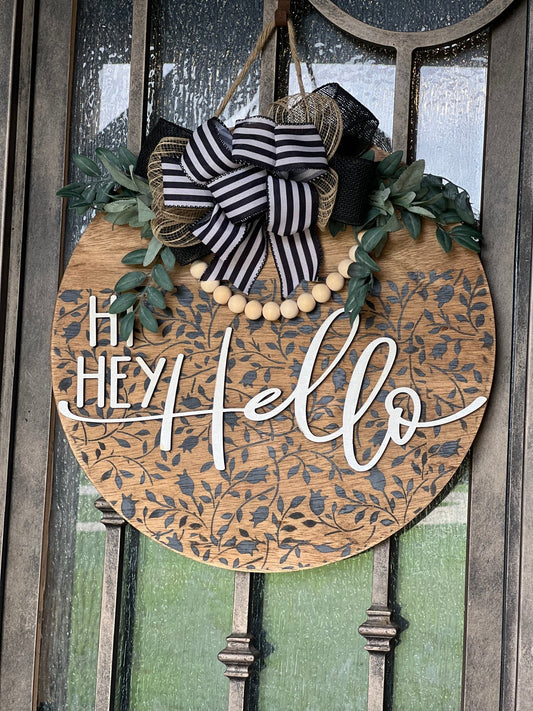 Round wood black Mini Flower and Vine door sign with natural wood accents hanging on a metal door.