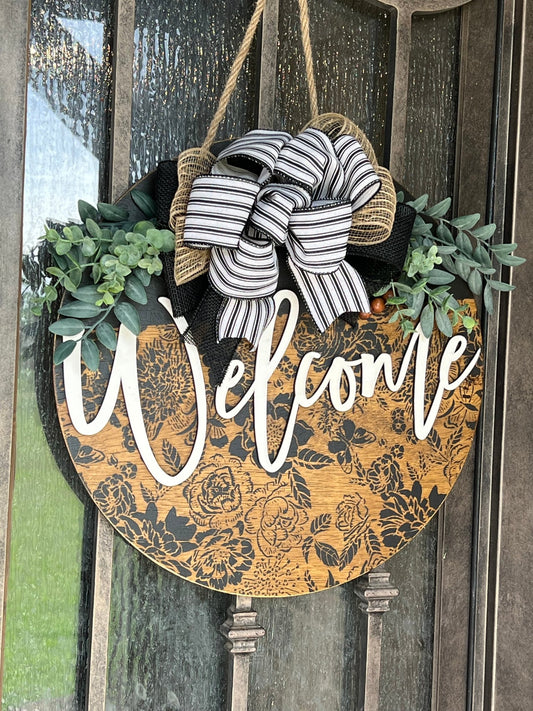 Wooden butterfly door hanger with floral design in natural wood and black accents hanging on metal door.