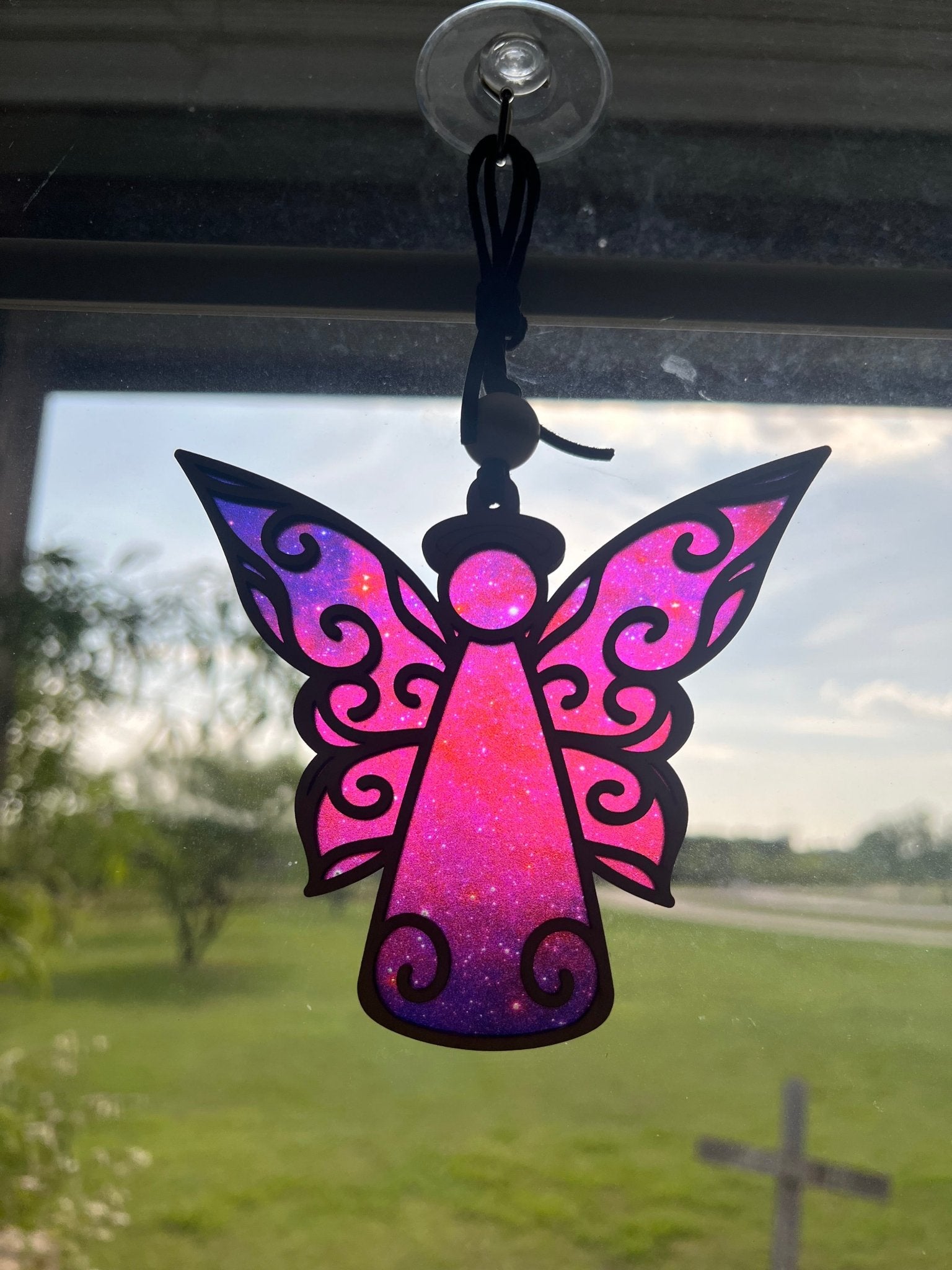Angel suncatcher with natural wood and multicolor acrylic, hanging in sunlight in sunlight.