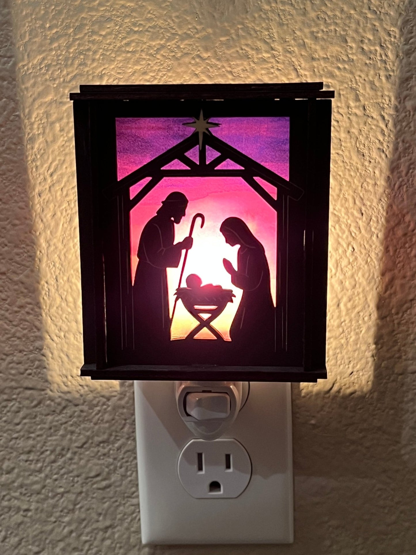 Black wood and multicolor acrylic Christmas Nativity Lantern Nightlight lit in hall front view.