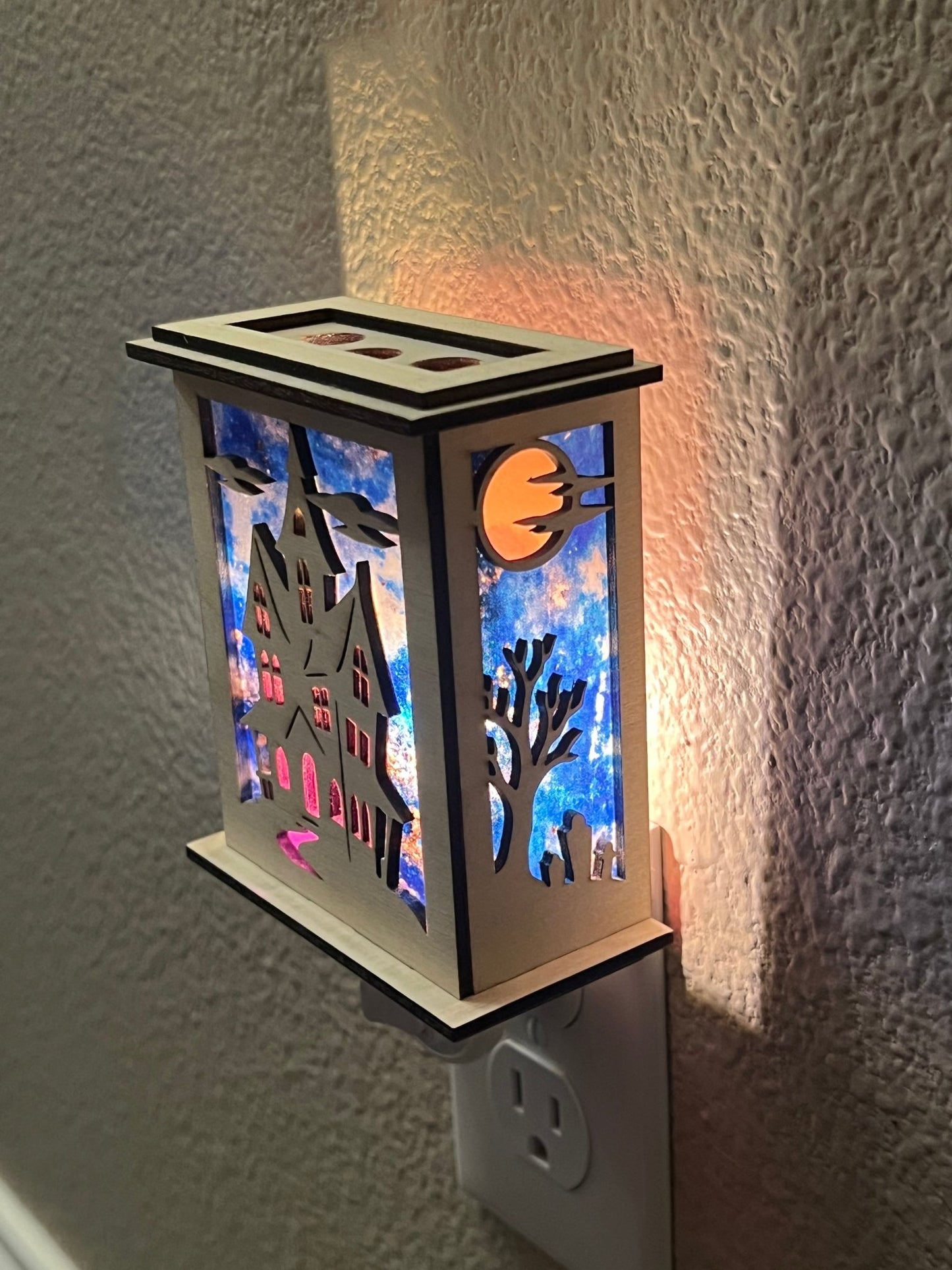Halloween Haunted House Lantern Nightlight made from wood and acrylic, showcasing rustic charm and multicolor glow lighted in a lit hallway with left view.