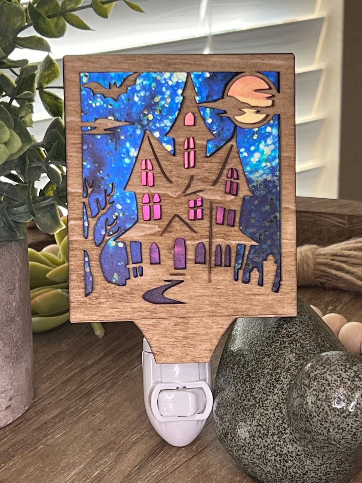 Haunted House Nightlight made of wood and acrylic, golden oak stained, rustic decor, front facing in sunlight..