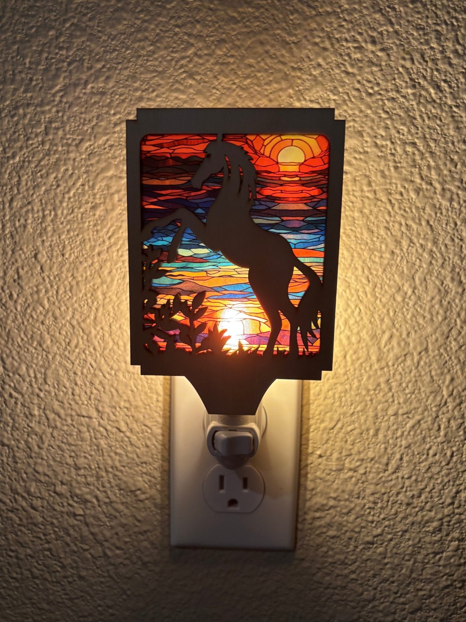A rustic horse nightlight made of wood and acrylic with a stained glass effect in sunlight.
