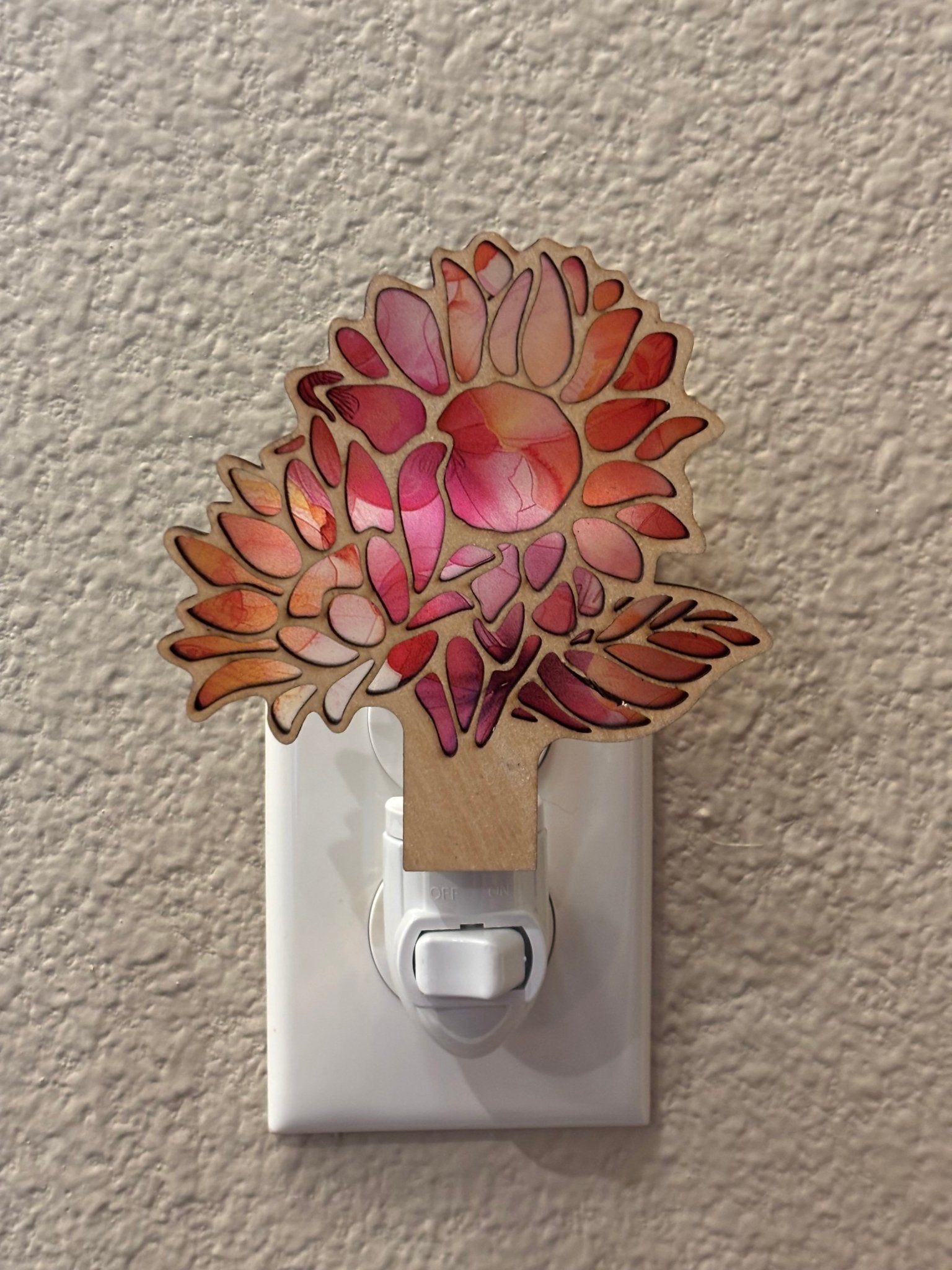A charming nightlight with pink and coral flower design on wood and acrylic, offering a rustic-modern feel.